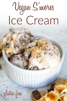 three scoops of ice cream in a white bowl on a table with crackers