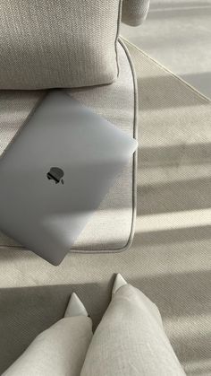 an apple laptop sitting on top of a couch