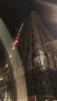 an image of a very tall building that is lit up in the dark night time