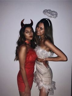 two women dressed up in costumes posing for a photo with horns on their heads and one wearing a red dress