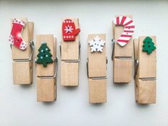 wooden clothes pegs with christmas decorations on them hanging from the side of a wall