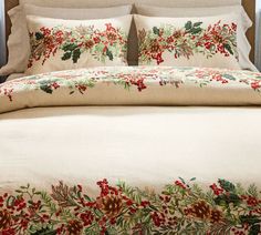 the comforter is adorned with red berries and pine cones on it's side