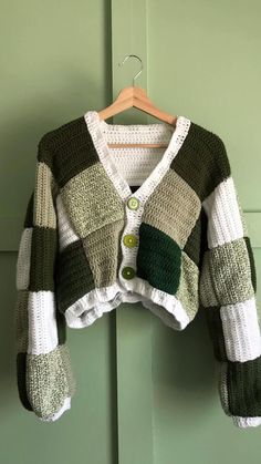 a green and white sweater hanging on a door