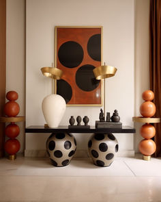 a table with two vases and chess pieces on it in front of a painting