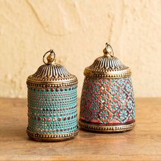 two decorative jars sitting on top of a wooden table