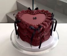 a red heart shaped cake sitting on top of a table