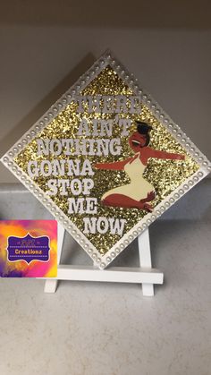 there is a gold and white graduation cap on the shelf next to it's holder