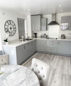 a kitchen with grey cabinets and white countertops is seen in this image from the dining room table