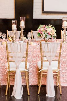 the table is set with gold chairs and white linens for an elegant wedding reception