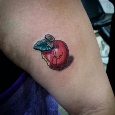 an apple tattoo on the left arm