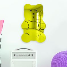 there is a yellow teddy bear with a cage in the window and a purple chair behind it