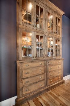 a large wooden cabinet with glass doors and drawers