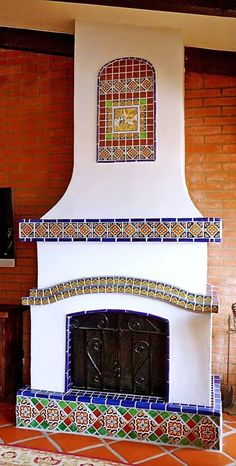 a white fireplace with colorful tiles on it