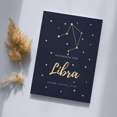 the notebook for libra is next to some dried flowers