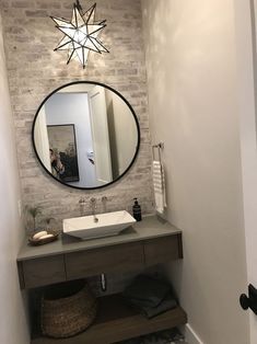 a bathroom with a sink, mirror and towel rack in it's corner on the wall