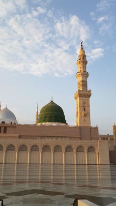 a large building with a green dome on top and two smaller buildings in the background