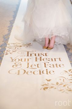 the bride is walking down the aisle with her wedding dress on and shoes in hand