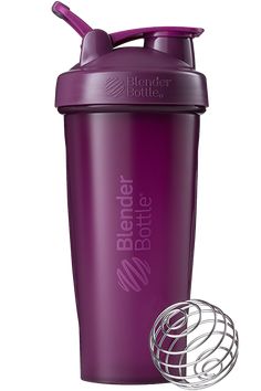 the blender bottle is purple and has a metal ball on it's side