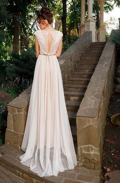 a woman in a wedding dress standing on some steps