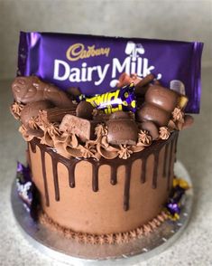 there is a chocolate cake decorated with candy and candies on the top, next to a bar of dairy milk