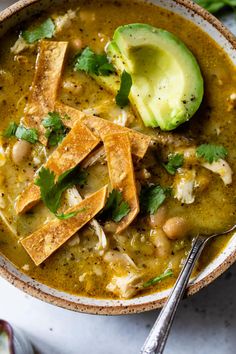 a bowl filled with soup and topped with avocado