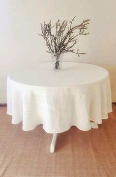 a table with a white cloth on it and a small plant in the centerpiece