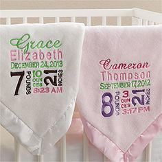 two personalized baby blankets hanging from a crib