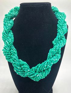 Stand out in style with this beautiful hand made braided style beaded necklace. Approximately 18" end to end. The Dorcas necklace is named after one of our ladies whose photo you will find within this collection. Dorcas is the group leader of our ladies and coordinates with our Kenya team lead Leila on orders and other business. Your purchase empowers women like Dorcas to build a sustainable business, alleviate extreme poverty and to support her family with dignity Green Beaded Multi-strand Turquoise Necklace, Green Multi-strand Hand-strung Beaded Necklaces, Green Braided Bohemian Jewelry, Team Lead, Sustainable Business, Seed Bead Necklace, Braid Styles, Bead Necklace, Seed Bead