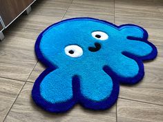 a blue rug with an octopus face on the floor in front of a cabinet door