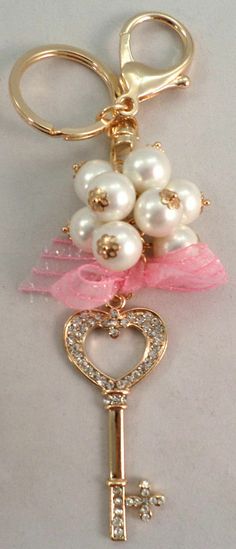 a gold key with pearls and pink ribbon