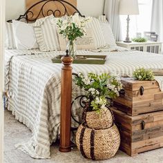 a bed sitting next to a wooden trunk with flowers on it