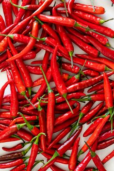 red hot peppers are scattered on a white surface