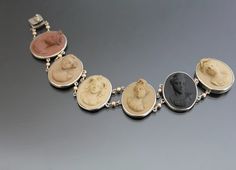 1880 - 1900's Victorian Roman cameo theme natural Lava bracelet. Silver plated brass mount (not tarnished). Excellent condition - no chips or cracks, no dents - and all the noses intact ;) Push button closure clasp works fine.  Length excluding clasp tongue:  6 3/4" (17,1cm).  Width: 15/16" (23mm). Weight:  21g. * * *  All our items are packed in gift boxes, easy to check of content and re-pack. If you wish something special, please let us know. Victorian Engraved Bracelets Collectible, Victorian Engraved Bracelet, Antique Carved Bracelets, Collectible Historical Jewelry With Antique Finish, Victorian Engraved Collectible Bracelet, Collectible Antique Finish Historical Jewelry, Cameo Bracelet, Lava Bracelet, Grand Tour