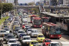 a busy street filled with lots of traffic next to tall buildings on either side of the road