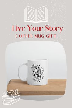 a coffee mug sitting on top of a wooden table next to an open book with the words live your story