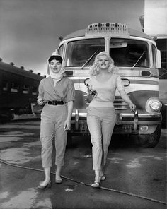 two women standing next to each other in front of a truck