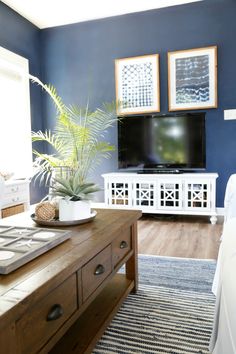 a living room filled with furniture and a flat screen tv on top of a wooden table