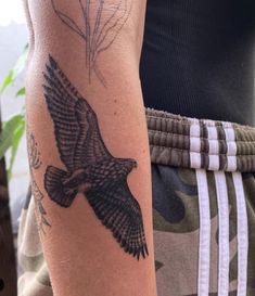 a person with a tattoo on their arm and an eagle in the middle of his arm