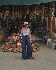 a woman is standing in front of a market