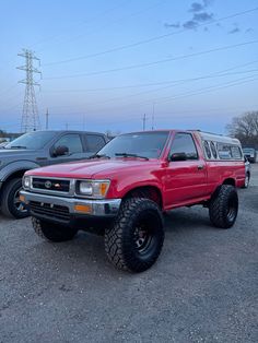 a red pick up truck parked in a parking lot