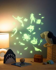 glow in the dark wall stickers on a desk next to a lamp and toy