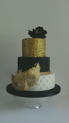 a three tiered cake with black and gold decorations