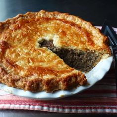 a meat pie on a plate with a knife and fork