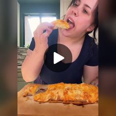 a woman is eating pizza with her mouth wide open