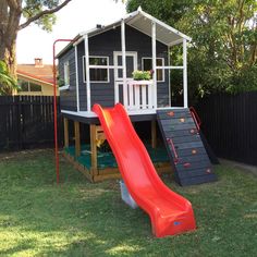 a small house with a slide in the back yard, and a play area for children