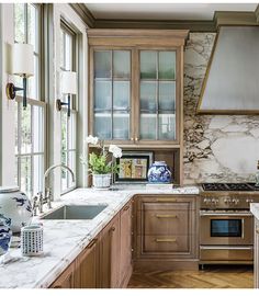 a kitchen with marble counter tops and wooden cabinets