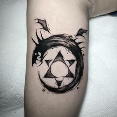 a black and white photo of a tattoo with an animal in the center on someone's arm