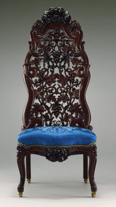 an ornate wooden chair with purple velvet upholstered on the seat and back side