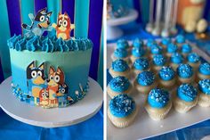 a cake and cupcakes with blue frosting on them are displayed next to each other