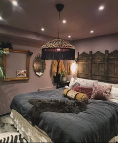 a large bed sitting in a bedroom next to a wall with mirrors and lights on it